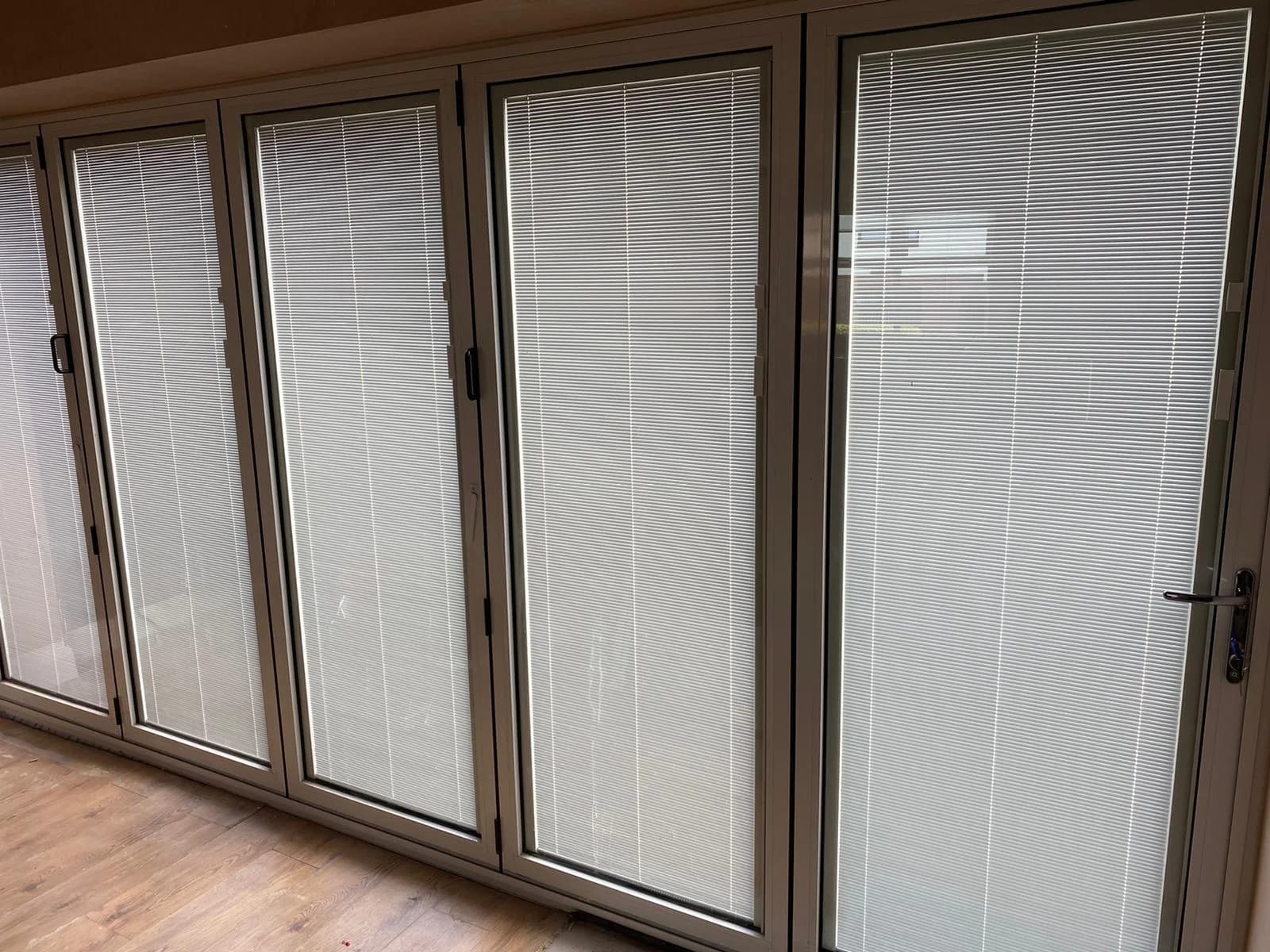 White internal bi-fold doors with integral blinds sealed inside the glass units
