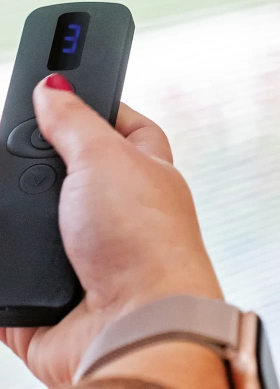 Hand holding the rechargeable remote control for an electric integral blind