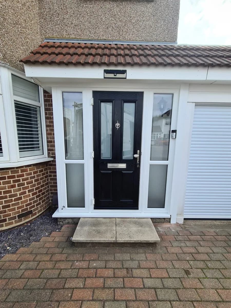Black composite front door with white uPVC side panels in a porch installed in Chigwell by Cii Double Glazing