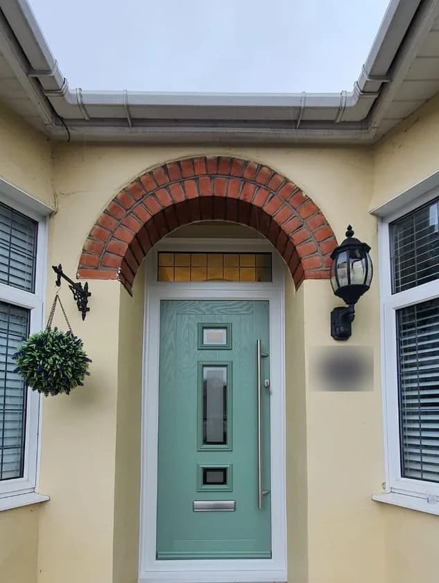 Chartwell green composite door fitted beneath a brick arched porch by Cii Double Glazing in Chigwell