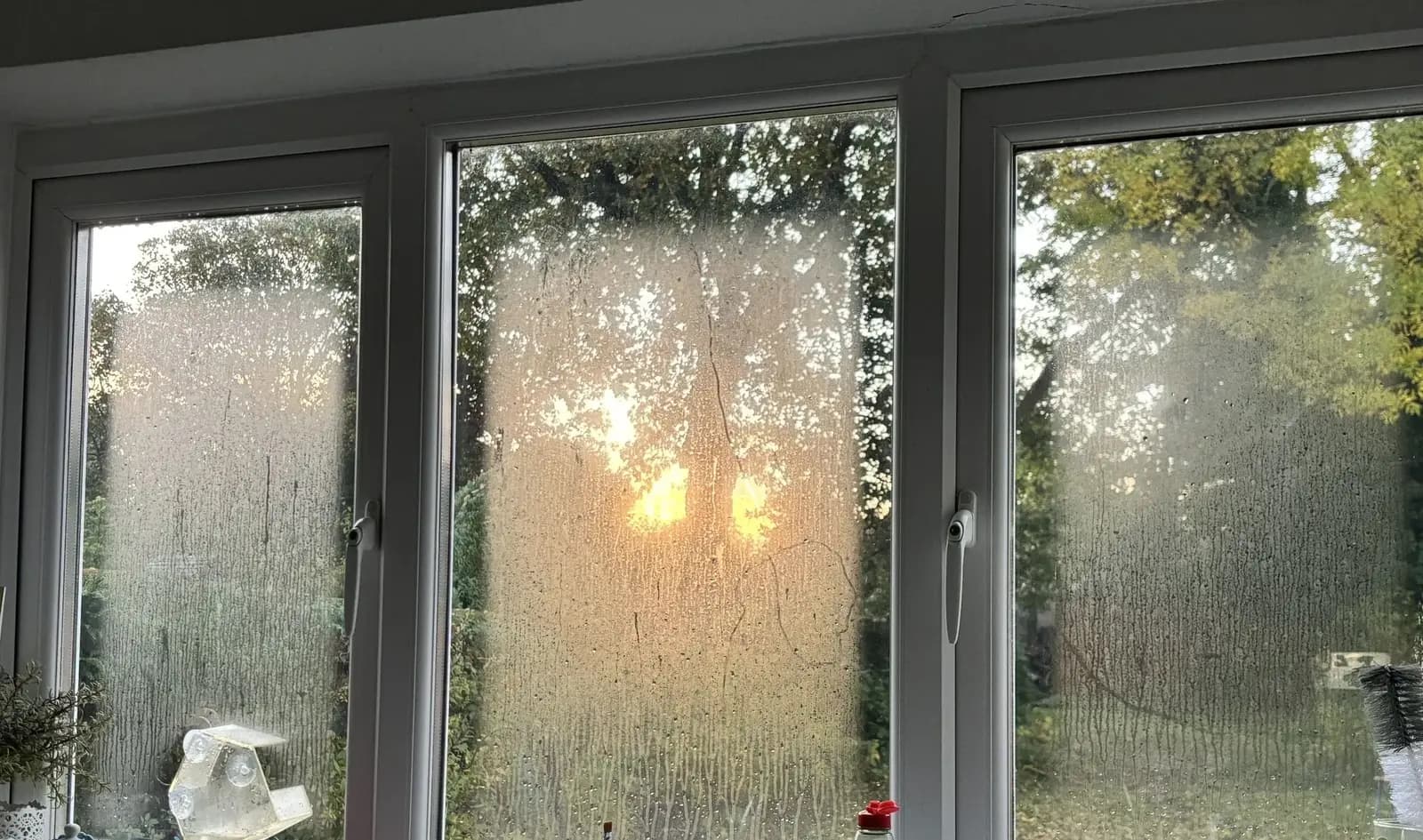 Three white uPVC casement panes with cloudy condensation trapped between the glass, a sign of failed sealed units