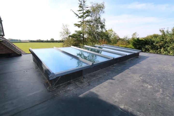 Long run of silver-grey aluminium flat roof glazing on an upstand over a rear extension in Romford, installed by Cii Double Glazing