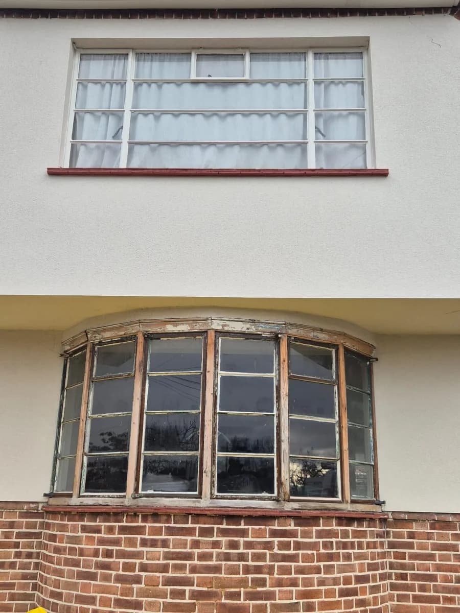 Ageing bay window and first-floor window before replacement on a rendered house in Chigwell surveyed by Cii Double Glazing